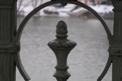 An iron fence frames the cold waters of the River Vltava