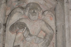 A carved angel at the base of an arch