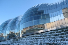 Newcastle quayside reflects in the glass of the Sage